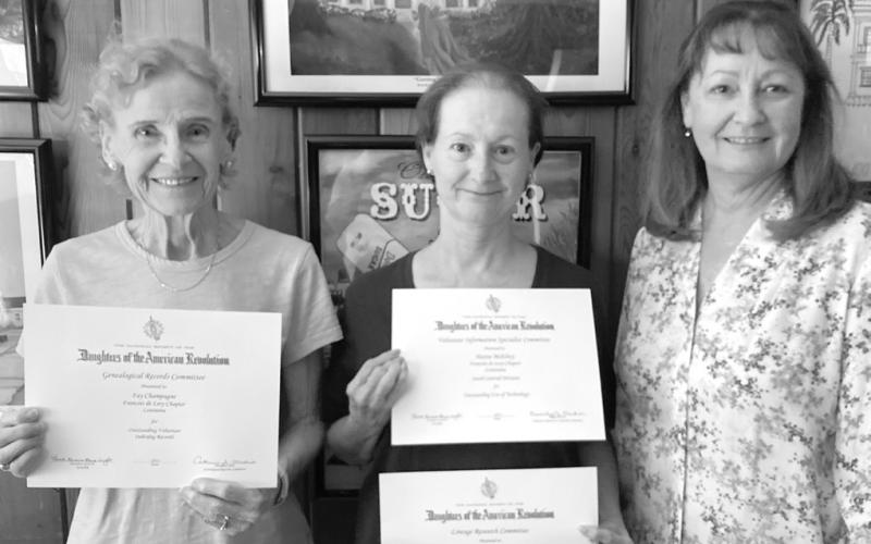 Regent Gayle Buckley presents Francois deLery Chapter Officers Fay Champagne and Hattie McElroy with certificates from the Louisiana Society Daughters of the American Revolution honoring their work in the areas of records indexing and use of technology in genealogical research. Pictured, from left: Fay Champagne, Hattie McElroy, and Gayle Buckley.