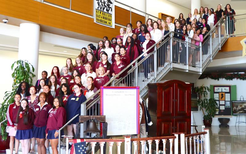 Mentors and CHS students on the staircase of the Chalmette High Cultural Arts Center Lobby.