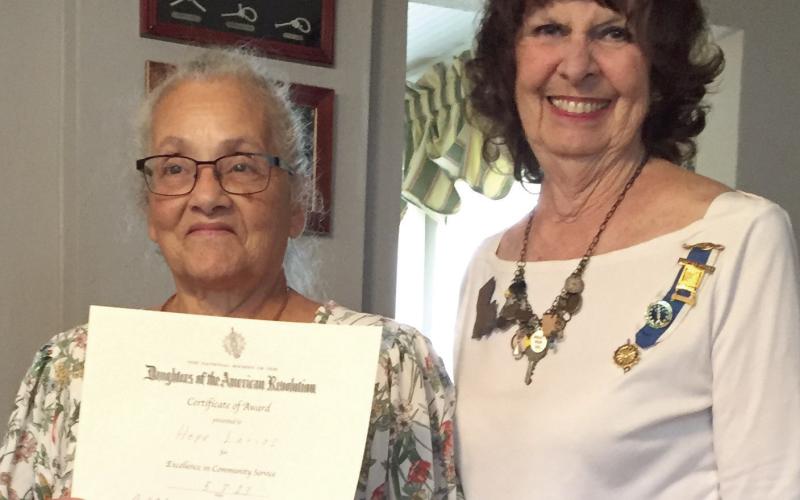 Francois de Lery Chapter, Daughters of the American Revolution held its annual tea at the Arabi home of Faith Moran. Receiving the DAR Community Service Award is Hope Larios (left) for volunteering over 700 hours within one year. Larios volunteers with the St. Bernard Volunteers for Family and Community (the St. Bernard VFC) and at the Community Center of St. Bernard. Presenting the award is Vice-regent Faith Moran.