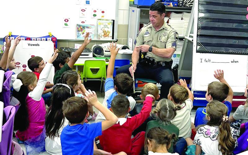 Sgt. Brian Canepa, SBSO recruiter, chats with Joseph Davis Elementary School students after he read a couple books to them during Literacy Week.