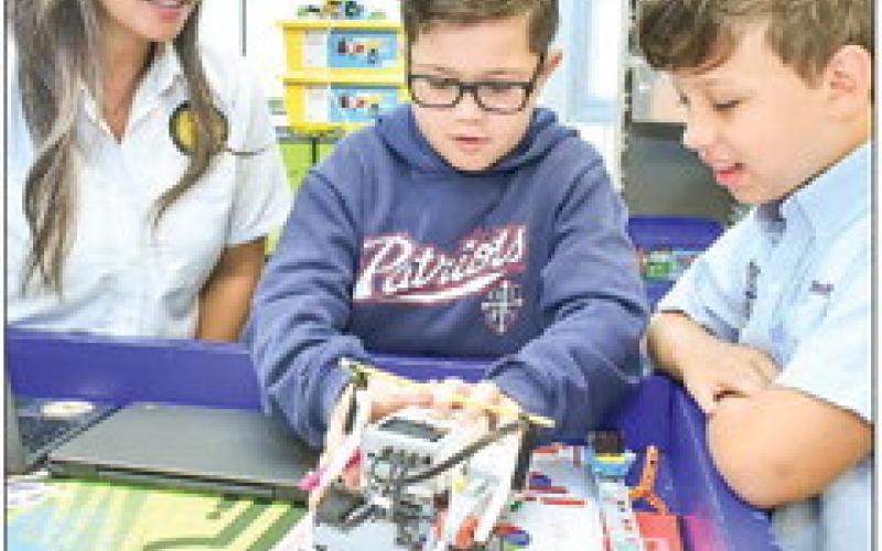 Our Lady of Prompt Succor former teacher Keena Van Court watches as sixth graders Enzo Lauro and Brenton Willheit works on STREAM activities.