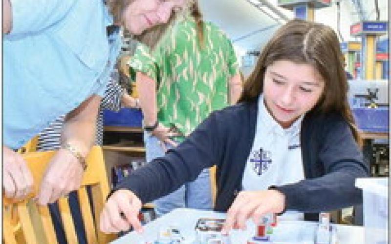 Our Lady of Prompt Succor teacher Kathy Scheuermann watches as sixth grader Addisyn Amadeo works on STREAM activities.