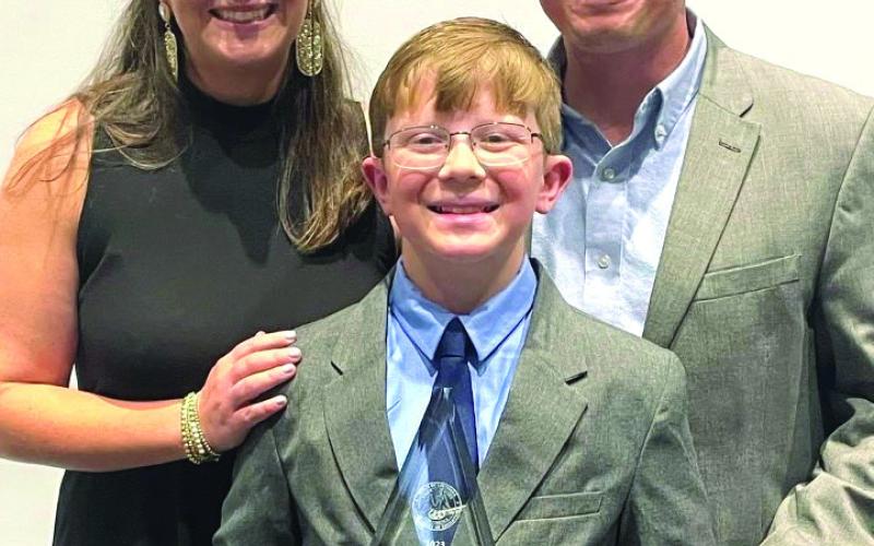 Jack McMullin (center) poses with mom Meaghan McMullin (left) and dad Jeremy McMullin for a photo after winning Elementary School Student of the Year.