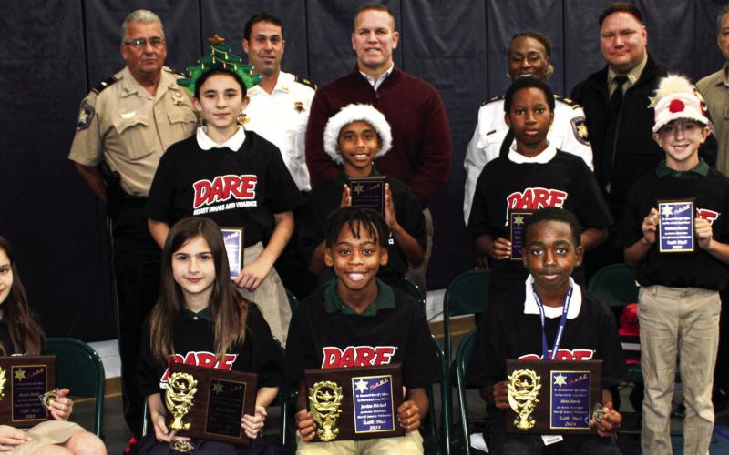 Joseph Davies Elementary fifth graders who were named St. Bernard Sheriff’s Office D.A.R.E. program firstplace essay contest winners are first row, from left: Harper Hardy, Giana Buras, Jordan Mitchell and Alvin Harris. Second-place winners are second row, from left: Murphy DeJean, Brody Duplessis, Giovanni Britton and Maddox Acosta. With the winners are, third row, from left: Lt. Robert Broadhead, Capt. Matthew Arcement, Maj. Daniel Bostic, Capt. Lisa Jackson, Sgt. Brandon Lewis and Sgt. Darrin Miller.
