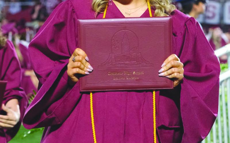 Senior Zaylee Wolfe smiles after receiving diploma.