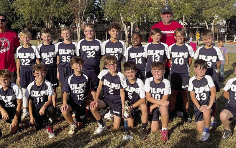 Members of the Our Lady of Prompt Succor Junior Flag Football team are shown. Back row, from left: Coach Dirck Duncan, Jase Fazzio, Talan Chilton, Michael Warden, Landon Pichon, Christian Fernandez, Alton Brown, Jack Bazile, Colby Barnes, Avery Sanchez, and Coach Terry Christoffer, standing behind the boys on the right. Front row, from left: Roy Lally, Travis Guillot, Colby Duncan, Beckett Christoffer, Clay Carlin, Chad Stechmann, Gabriel Roques, and Kaiden Riche.