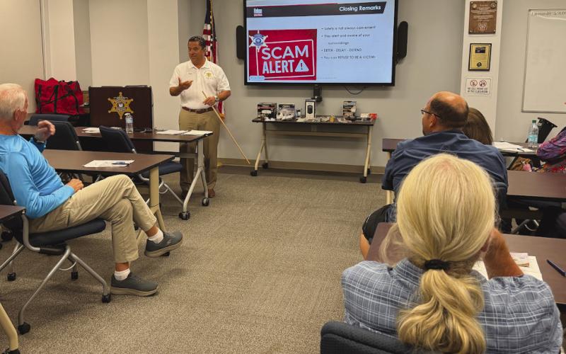 Col. Chad Clark, commander of the Criminal Investigations Bureau, speaks to attendees of SBSO's "Refuse To Be A Victim" class about recent scams targeting residents and the number of cases investigators handle each year, emphasizing the importance of staying alert and informed.