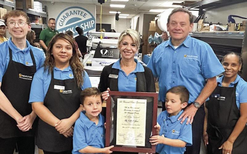 New UPS Store workers pose for a photo after their ribbon-cutting ceremony.