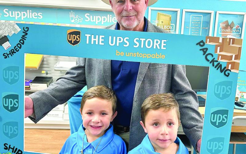 Parish president Louis Pomes and Galdamez brothers Roman and Greyson celebrate the ribbon cutting for the new UPS Store in Chalmette.