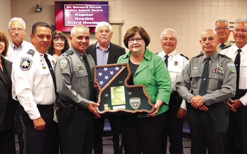 Superintendent of Law Enforcement at the Louisiana Department of Wildlife and Fisheries Stephen Clark, along with Doris Voitier and family members, pose with Law Enforcement and shadowbox gift honoring the memory of the late Colonel Paul Voitier.