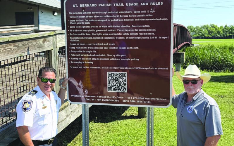 Col. Chad Clark, commander of the SBSO Criminal Investigations Bureau, left, and Parish President Louis Pomes stand beside a new trail safety sign installed through a partnership between SBSO and SBPG to enhance safety along the parish’s bikeway and trail system. The initiative also includes the installation of more than a dozen surveillance cameras along the trails.