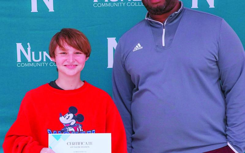 Student Alexander Penn receives a completion certificate from program mentor Dr. Jordan Sanchez during the Bridge Program and Summer Career Exploration completion ceremony.