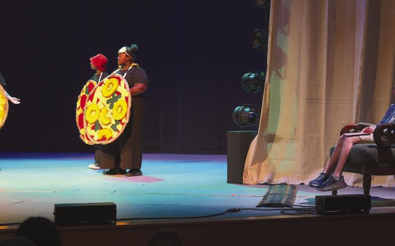 Alyssa Franatovich watches her play, performed by Prescription Joy, from the chair of honor on stage