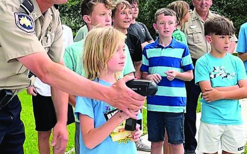 St. Bernard Sheriff's Office's Lieutenant Brent Bourgeois (left) demonstrates how to use the speed radar to this year's Junior Deputies. Since 2015, the Junior Deputy Academy is designed to teach children ages 10 to 13 about the various aspects of law enforcement.