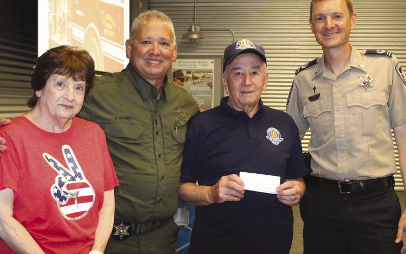 Lt. Eric Eilers, second from left, and Chaplain Aaron Johnson, far right, accept a $100 donation for the Junior Deputy Academy from Hilton Preau, president of the Vietnam Veterans of America, St. Bernard Chapter 550, and Patricia Preau. Junior Deputy Academy is an annual summer program for children ages 10 to 12 designed to foster community pride and teach youngsters about law enforcement.