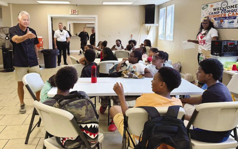 Sheri Pohlmann talks with campers during Christian Fellowship Church’s Camp Conquer Summer Camp Law Enforcement Day. The Sheri