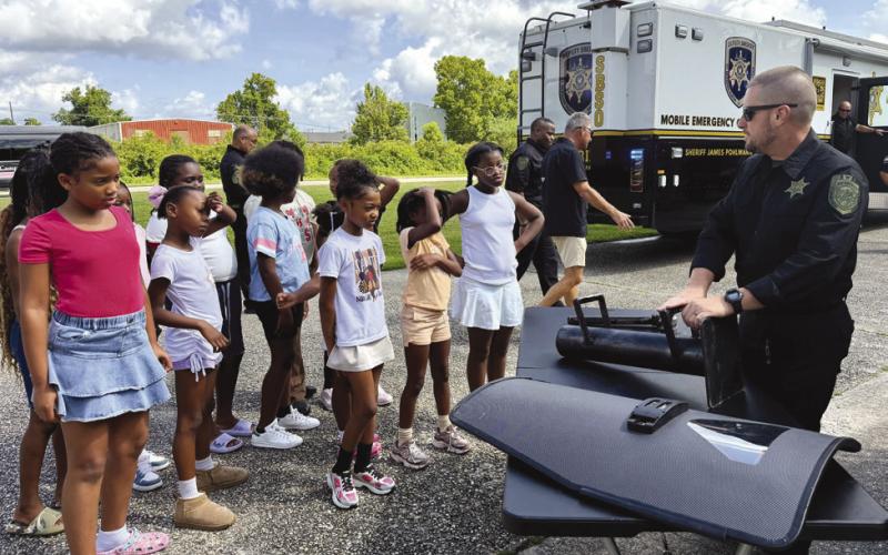 Lt. David Culpepper of the Special Operations Division shows Camp Conquer participants a ballistic shield and other specialized equipment used by SBSO.