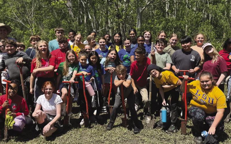 Belle Chasse Middle School students pose for a group photo after planting 363 native trees in Port Sulphur - the rewarding culmination of their . rst year participating in the LSU Coastal Roots