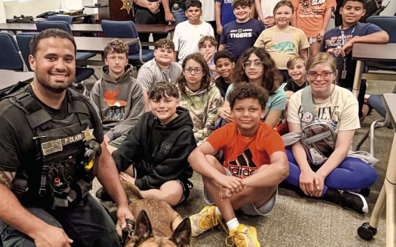 Col. Daniel Bostic Jr., commander of the Special Investigations Division, along with several Narcotics Agents and K-9 Pit taught Junior Deputies about drug investigations and the important role police dogs play in law enforcement. Also pictured with the kids are: Capt. Matthew Arcement, Lt. James Wood, Agent Jason Saltalmachia, Agent and K-9 Handler Patrick Clark, Agent Rhett Fleetwood, and Lt. SRO Marco Spicuzza.