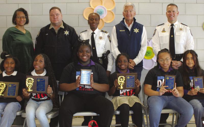 W. Smith Jr. Elementary School fifth graders who were named SBSO D.A.R.E. program essay contest winners are, first row, from left: Anaya Williams, first place; Kyrie Major, first place; Breanna Dixon, second place; Ja'harii Cosse, first place; Kylie Sider, second place; and Angela Ticas Turcios, second place. With the winners are, second row, from left, are: W. Smith Elementary School Principal Cassandra Reddick, Sgt. Brandon Lewis, Capt. Lisa Jackson, Sheri James Pohlmann and Col. Daniel Bostic.