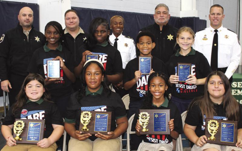 Joseph Davies Elementary School fifth graders named SBSO D.A.R.E. program first-place essay contest winners are, first row, from left: Sebastien Guerrero, Sofia Delorbe Santiago, Kaylee Cameron and Stephanie White. Second-place essay contest winners are, second row, from left: Journee Hawkins, Rylee Jolly, Rodney Brisco III and Braylie Areas. With the winners are, third row, from left: Lt. Brad Nuccio, Sgt. Brandon Lewis, Capt. Lisa Jackson, Deputy Chief John Doran and Col. Daniel Bostic.