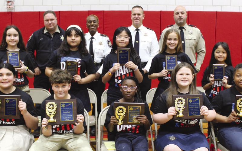 Lacoste Elementary School fifth graders who were named SBSO D.A.R.E. program first-place essay contest winners are first row, from left: Ava Oramous, Lance Sider, Kenzie Badon, Charlotte St. Germain and Taylor Moore. Secondplace essay contest winners are, second row, from left: Alayna Hoey, Kailey Espino Arredondo, Anne Chen, Morgan Nevels and Angel Benazo. With the winners are, third row, from left: Sgt. Brandon Lewis, Capt. Lisa Jackson, Col. Daniel Bostic and Lt. Brad Nuccio.
