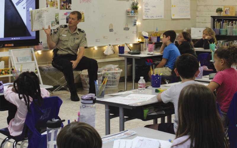 Chaplain Dep. Aaron Johnson reads to students at Joseph Davies during Literacy Week activities.