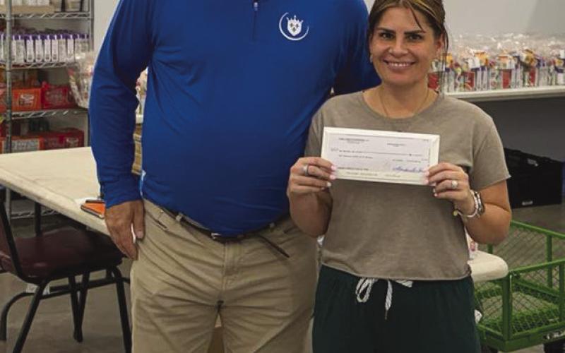 Emmett Dupas presents a check to the Community Center's Jamie Richardson.