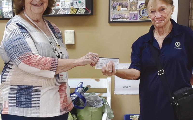 AARP Chapter 3926 President Leona Galley (left) giving a donation to guest speaker Cathy Landry of Friends of the Animal Shelter of St. Bernard (right).