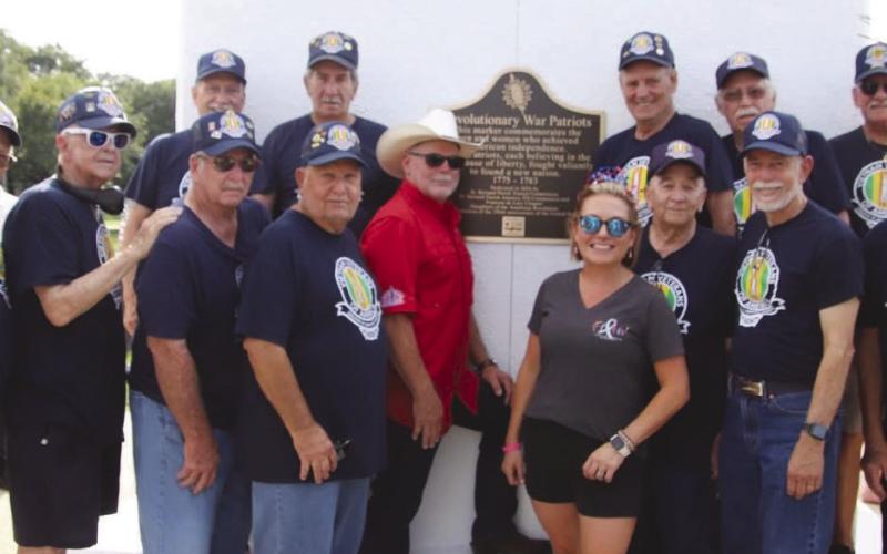 Members of VVA Chapter 550 posing for a photo with parish president Louis Pomes in front of the Vietnam Veterans War Memorial.