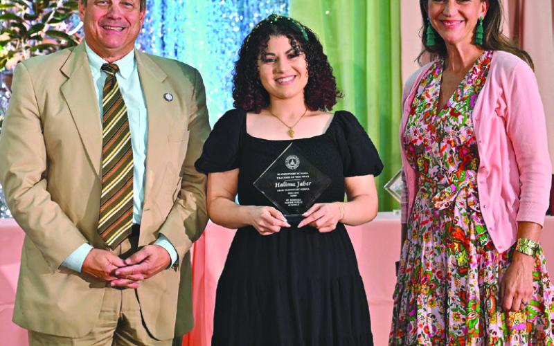 Halima Jaber (center) was one of the 12 Teachers of the Year recognized. Also pictured: School board members Sean Warner and Millie Harris.