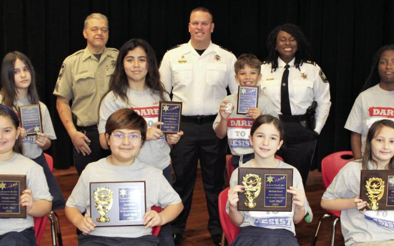 J.F. Gauthier Elementary held a graduation Jan. 4 for fifth graders who graduated from the St. Bernard Sheriff’s Office D.A.R.E. program. First-place essay contest winners are, first row, from left: Autumn Arabie, Lincoln Ruiz, Madison Nunez and Allison Matlock. Second-place essay contest winners are, second row, from left: Everleigh Barbaro, Elizabeth Ramos, Kohen Ruiz and Ron’Janae Stewart. Third row, from left, are: Sgt. Darrin Miller, Maj. Daniel Bostic and Capt. Lisa Jackson.