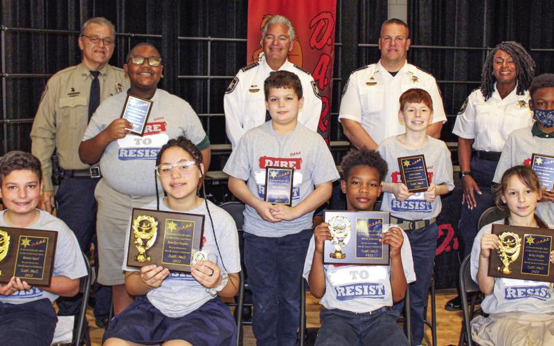 Meraux Elementary held a graduation Dec. 13 for fifth graders who graduated from the St. Bernard Sheriff’s Office D.A.R.E. program. First-place essay contest winners are first row, from left: Roman Appel, Kourtlyn Peeples, Maceo Johnson and Keiley Graffia. Second-place essay contest winners are second row, from left: Torrian Cannon, Ethan Stewart, Collin Lanier and Colby Fortner. Third row, from left, are: Sgt. Darrin Miller, Sheriff James Pohlmann, Maj. Daniel Bostic and Capt. Lisa Jackson.