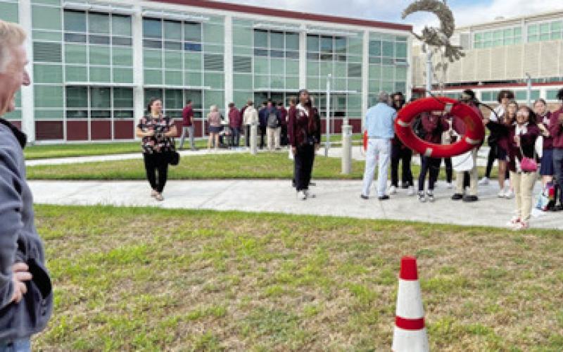 Drew Heaphy, the St. Bernard Port, Harbor and Terminal’s Executive Director, smiles as a student from Chalmette High participates in the ring toss for the Who Works the Rivers event. Photo by Arthur Yves