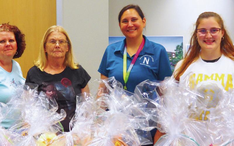 Participants pose for a photo with the assembled baskets for children who are in the Family Violence Program of St. Bernard.