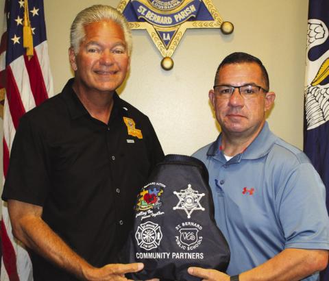 Sheri James Pohlmann and SBSO Sgt. Jerey Vega, a board member of the St. Bernard Autism Awareness Krewe, with sensory bags designed to help equip deputies with tools to better assist individuals with autism or sensory sensitivities during emergency situations.