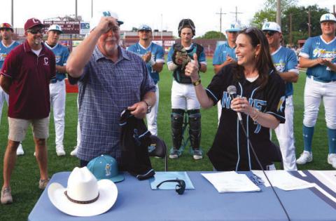 Parish President Louis Pomes trades his signature cowboy hat for a Nunez Baseball hat after joining Nunez Chancellor Tina Tinney in signing a land donation agreement that transfers ownership of a tract of land on De La Ronde Drive to Nunez to serve as the future site of Nunez Baseball’s home stadium. Behind them, Nunez Baseball Coach Glenn Powell, Chalmette High Baseball Coach Jason Tucker and Nunez Baseball players look on.