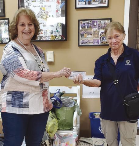 AARP Chapter 3926 President Leona Galley (left) giving a donation to guest speaker Cathy Landry of Friends of the Animal Shelter of St. Bernard (right).