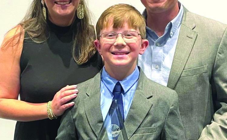 Jack McMullin (center) poses with mom Meaghan McMullin (left) and dad Jeremy McMullin for a photo after winning Elementary School Student of the Year.