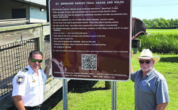 Col. Chad Clark, commander of the SBSO Criminal Investigations Bureau, left, and Parish President Louis Pomes stand beside a new trail safety sign installed through a partnership between SBSO and SBPG to enhance safety along the parish’s bikeway and trail system. The initiative also includes the installation of more than a dozen surveillance cameras along the trails.