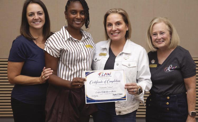 Roshonda Tolbert, second from left, receives her Certi. ed FLAW Warrior Mentor certi. cate, Sept. 19, 2026. With her, from left, are Jennifer Medus, Taysha D. Gibbs, and Tammy Sperandeo. Photo credit: Garrett Dipuma for FLAW Foundation