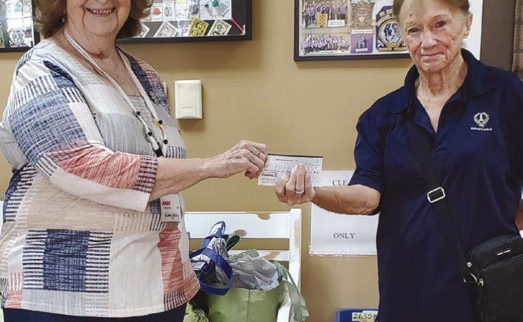 AARP Chapter 3926 President Leona Galley (left) giving a donation to guest speaker Cathy Landry of Friends of the Animal Shelter of St. Bernard (right).